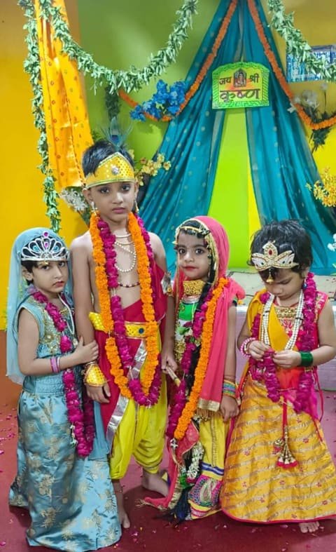 Children dressed as Krishna and Radha wearing marigold garlands