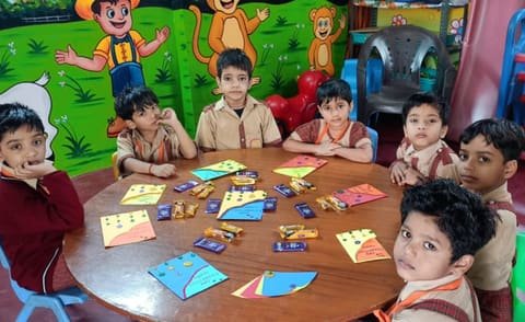 Children around a round table with colourful paper kites they made