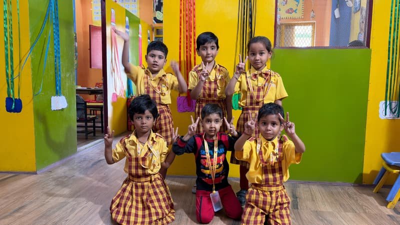 A group of children in school uniform in the brightly painted school corridor