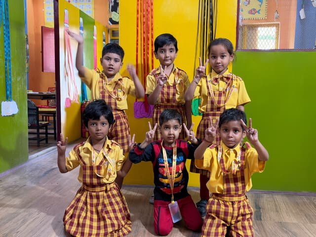 A group of children in school uniform in the brightly painted school corridor